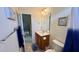 Cozy bathroom with single vanity, warm lighting and adjacent access to additional attic storage space at 404 Braxman Ln, Holly Springs, NC 27540