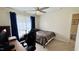 Cozy bedroom featuring a ceiling fan, plush carpet, and ample natural light at 404 Braxman Ln, Holly Springs, NC 27540