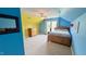 Colorful bedroom with a painted blue and yellow walls, a large window, and a comfortable bed at 404 Braxman Ln, Holly Springs, NC 27540