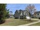 Charming two-story home with gray siding, manicured lawn, and mature landscaping at 404 Braxman Ln, Holly Springs, NC 27540