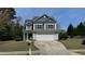 Charming two-story home showcasing a manicured lawn, blue siding, and attached two-car garage at 404 Braxman Ln, Holly Springs, NC 27540