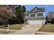 Charming two-story home showcasing a manicured lawn, blue siding, and attached two-car garage at 404 Braxman Ln, Holly Springs, NC 27540