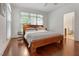 Well-lit bedroom with hardwood floors, ceiling fan and a traditional wooden bed frame at 407A Hillsborough St, Chapel Hill, NC 27514
