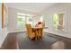 Bright dining room with wood table, six chairs, modern light fixture, and large windows overlooking the yard at 407A Hillsborough St, Chapel Hill, NC 27514