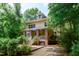 Inviting yellow two-story home boasts a brick porch, lush landscaping, and a welcoming entrance at 407A Hillsborough St, Chapel Hill, NC 27514