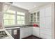 Modern kitchen with white cabinets, quartz countertops, stainless steel appliances, and a bright window at 407A Hillsborough St, Chapel Hill, NC 27514