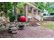 Brick patio with fire pit and firewood in a shady landscaped backyard at 407A Hillsborough St, Chapel Hill, NC 27514