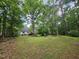 Spacious backyard with a wooden deck, surrounded by mature trees at 4116 Tall Pine Dr, Franklinton, NC 27525