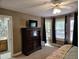 Bedroom showcases dark wood dresser with TV and a bay window with curtains at 4116 Tall Pine Dr, Franklinton, NC 27525