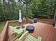 Outdoor deck with seating, an umbrella, and a cooking area with forest view at 4116 Tall Pine Dr, Franklinton, NC 27525