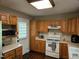 Traditional kitchen features oak cabinets, white appliances, and access door at 4116 Tall Pine Dr, Franklinton, NC 27525