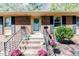 Inviting front entrance with brick steps, decorative plants, and a charming blue front door at 412 Winterlocken Dr, Sanford, NC 27330