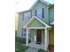 Charming two-story townhome featuring green siding, black shutters, and a welcoming covered front porch at 4425 Moss Garden Path, Raleigh, NC 27616