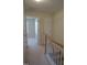 Upstairs hallway with wood banister and neutral carpet leading to bedrooms at 4425 Moss Garden Path, Raleigh, NC 27616