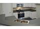 Modern kitchen featuring white cabinets, dark countertops, and stainless-steel appliances at 4425 Moss Garden Path, Raleigh, NC 27616