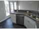 Bright kitchen features stainless steel dishwasher, double basin sink, white cabinets and tiled floors at 4425 Moss Garden Path, Raleigh, NC 27616