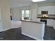 Open concept kitchen features breakfast bar, tiled floors, and stainless steel appliances at 4425 Moss Garden Path, Raleigh, NC 27616