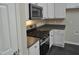 Updated kitchen with white cabinets, stainless steel appliances, and dark countertops at 4425 Moss Garden Path, Raleigh, NC 27616