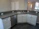 Open kitchen featuring stainless steel dishwasher and sink with white cabinets at 4425 Moss Garden Path, Raleigh, NC 27616