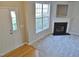 Open-concept living room with fireplace and large window at 4425 Moss Garden Path, Raleigh, NC 27616