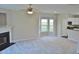 Bright living room features a fireplace, neutral carpet, ceiling fan, and large bay window at 4425 Moss Garden Path, Raleigh, NC 27616
