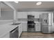 Well-lit kitchen with stainless steel appliances, white cabinets, and modern countertops at 4447 Antique Ln, Raleigh, NC 27616