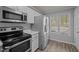 Clean kitchen featuring stainless steel appliances, white cabinetry, and natural light at 4447 Antique Ln, Raleigh, NC 27616