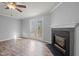 Bright living area featuring fireplace, ceiling fan, glass doors to outside, and hardwood floors at 4447 Antique Ln, Raleigh, NC 27616