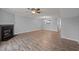 Cozy living room with a warm fireplace, ceiling fan, and view into the kitchen at 4447 Antique Ln, Raleigh, NC 27616