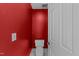 Cozy bathroom featuring bright red walls, white toilet and door and light fixtures at 5122 Berkeley St, Raleigh, NC 27612