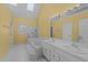 A yellow bathroom with dual sinks, a jacuzzi tub, and a walk-in shower at 5122 Berkeley St, Raleigh, NC 27612