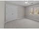 Cozy bedroom with a double-door closet, neutral carpeting, and bright natural light from the window at 5122 Berkeley St, Raleigh, NC 27612