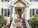 A close up of the home's front door with brick steps and white railings at 5122 Berkeley St, Raleigh, NC 27612