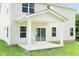 A home's backyard features a covered patio with a sliding glass door leading inside, all in neutral tones at 557 Freedom Trail Dr, Willow Springs, NC 27592