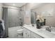 Bright bathroom with double sink vanity, framed mirror, and tiled shower at 557 Freedom Trail Dr, Willow Springs, NC 27592