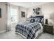 Comfortable bedroom with a plaid comforter and plenty of natural light at 557 Freedom Trail Dr, Willow Springs, NC 27592