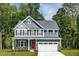 Charming two-story home showcasing a red front door, a two-car garage, and beautiful architectural details at 557 Freedom Trail Dr, Willow Springs, NC 27592