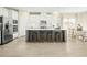 Bright kitchen boasts white cabinets, stainless steel appliances, a large island with seating, and stylish backsplash at 557 Freedom Trail Dr, Willow Springs, NC 27592