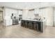 Bright kitchen boasts white cabinets, stainless steel appliances, a large island with seating, and stylish backsplash at 557 Freedom Trail Dr, Willow Springs, NC 27592