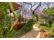Lush backyard with stone-lined path leading to a wood deck with trellis at 620 Wills Forest St, Raleigh, NC 27605