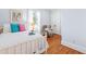 Bright bedroom with white bedding, accent pillows and chair with hardwood flooring at 620 Wills Forest St, Raleigh, NC 27605