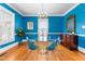 Vibrant dining room with unique blue walls, a modern chandelier, and stylish transparent chairs at 620 Wills Forest St, Raleigh, NC 27605