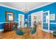 Bright dining room featuring blue walls, chandelier lighting, and glass-topped table with seating at 620 Wills Forest St, Raleigh, NC 27605