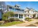 Charming blue two-story home boasts a welcoming front porch and manicured landscaping at 620 Wills Forest St, Raleigh, NC 27605
