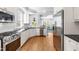 Bright kitchen with stainless steel appliances and hardwood floors, and an open view to the living room at 620 Wills Forest St, Raleigh, NC 27605