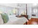 Bright main bedroom features white bedding, hardwood floors and access to balcony at 620 Wills Forest St, Raleigh, NC 27605