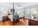 Spacious main bedroom with four-poster bed, windows and access to outdoor deck at 620 Wills Forest St, Raleigh, NC 27605