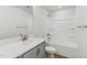 Modern bathroom features a shower-tub combo, a gray vanity, and luxury vinyl plank flooring at 628 Brittany Ct, Durham, NC 27703