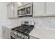 Close-up of kitchen with stainless steel oven and microwave, white countertops and light gray cabinets at 628 Brittany Ct, Durham, NC 27703
