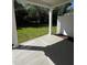 An outdoor patio with a concrete floor, surrounded by green trees and plants at 628 Brittany Ct, Durham, NC 27703